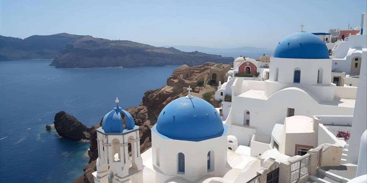 Home to blue-domed churches perched above a volcanic caldera, Santorini is part of which sun-drenched country