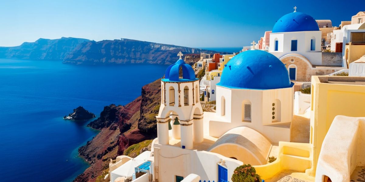 Famous for its blue-domed churches that overlook a volcanic caldera, Santorini is part of which sunny country