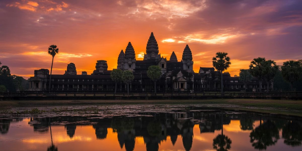 Which city, known for the historic Angkor Wat, is featured in this sunset view